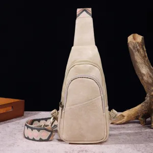 Vista detallada de un bolso bandolera bohemio beige de piel sintética con correa bordada