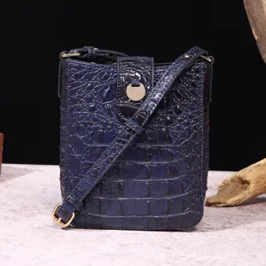 Primer plano del bolso para móvil retro azul con relieve de cocodrilo y herrajes.