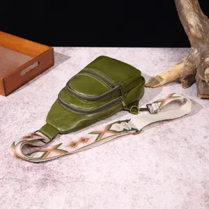 Detalle de un bolso de pecho vintage verde con una correa tejida de estilo bohemio.