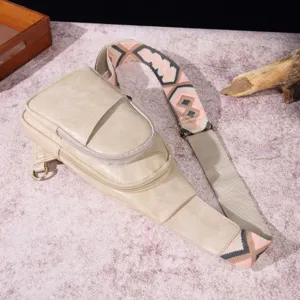 Detalle de bolso bandolera beige vintage con una correa tejida de estilo bohemio