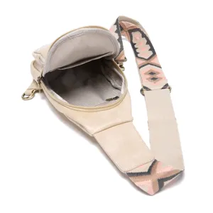 Detalle de bolso bandolera beige para mujer con correa bohemia y forro de chevrón
