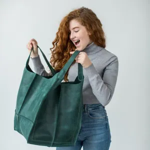 Detalle que muestra la gran capacidad y la textura suave del bolso tote de cuero verde