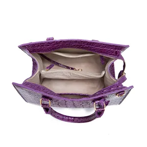 Vista superior detallada de bolso morado con relieve de cocodrilo e interior espacioso