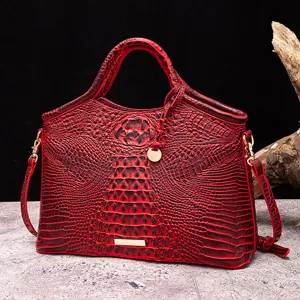 Primer plano de bolso vintage rojo con textura de cocodrilo 3D y herrajes dorados.