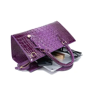 Vista detallada de la gran capacidad del bolso morado de piel con relieve de cocodrilo