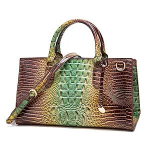 Vista detallada de la textura de cocodrilo vintage en este bolso de mano verde degradado.