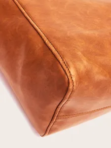 Primer plano de la textura de cuero encerado vintage y costuras de un bolso café
