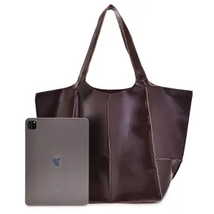 Referencia de tamaño del bolso tote de cuero marrón grande junto a una tableta iPad