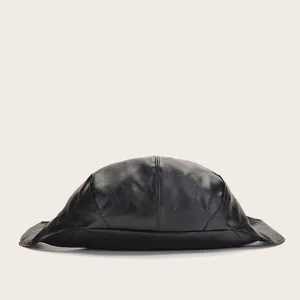 Primer plano de una mochila retro de cuero negro suave con silueta de escarabajo