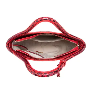 Vista detallada del interior de un bolso rojo con textura de cocodrilo y bolsillos