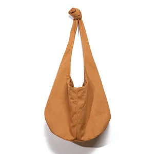 Detalle de un bolso hobo vintage de lona de algodón marrón con una elegante correa de nudo