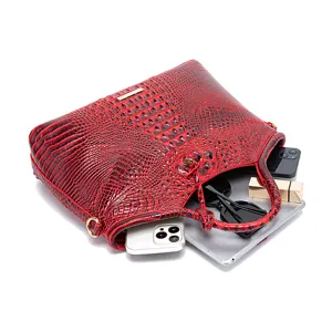 Detalle del bolso rojo con textura de cocodrilo y gran capacidad interior