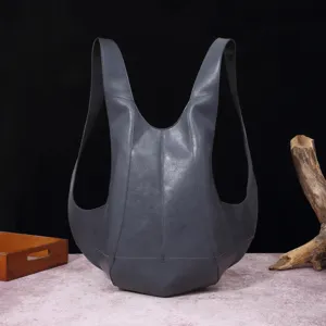 Vista detallada de una mochila vintage de cuero gris con forma de escarabajo y silueta