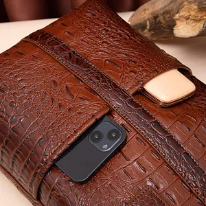 Detalle de bolso vintage marrón con relieve de cocodrilo y bolsillos para el móvil