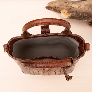 Vista superior de bolso vintage marrón con patrón de cocodrilo y amplio interior gris