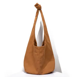 Vista detallada de un bolso hobo retro de lona marrón con correa anudada única