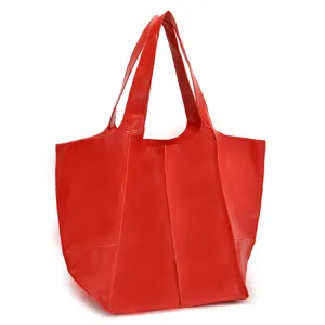 Vista detallada de un bolso tote grande de cuero suave encerado rojo con costuras.