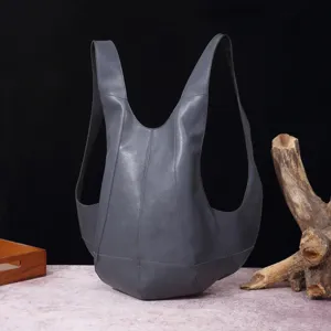 Vista detallada de una mochila vintage de cuero con forma de escarabajo y costuras únicas.