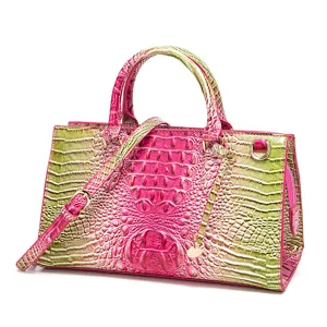 Detalle de un bolso de mano en piel con relieve de cocodrilo degradado rosa y verde