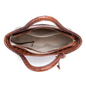 Vista interior de un bolso marrón vintage con diseño de cocodrilo y forro de tela