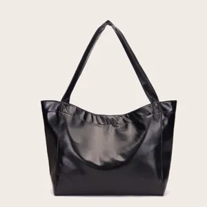 Primer plano de la textura de cuero encerado negro brillante de un bolso tote grande