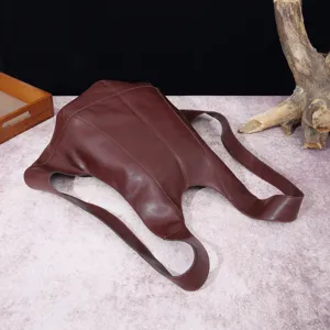 Vista detallada de mochila vintage de cuero marrón con costuras y diseño únicos.