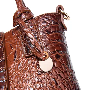 Vista detallada de la textura de patrón de cocodrilo en un bolso de cuero marrón vintage