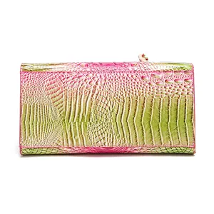 Vista detallada de la cartera de lujo para mujer con relieve de cocodrilo rosa y verde.