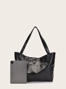 Bolso tote grande de piel sintética negra mostrado con tableta para escala de tamaño.