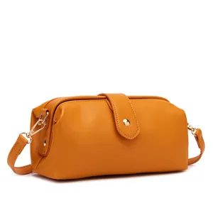 Close-up side view of a vintage mustard yellow doctor bag with elegant gold hardware