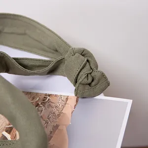 Primer plano de la correa de lona verde oliva con nudo decorativo y detalle de tejido