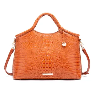 Detalle de bolso de mano vintage en cuero naranja con relieve de piel de cocodrilo