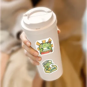 Detailed view of cute cartoon frog stickers applied on a white tumbler cup