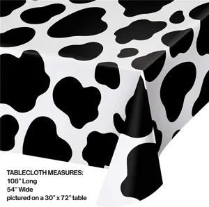 Détail de la nappe de fête à motif de vache avec des dimensions de 108 par 54 pouces