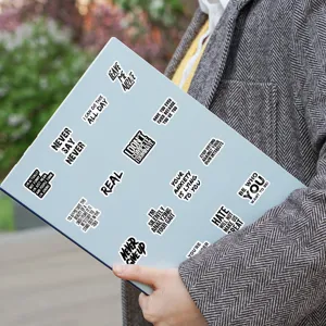 Detail view of black and white text stickers featuring motivational quotes on a blue folder.