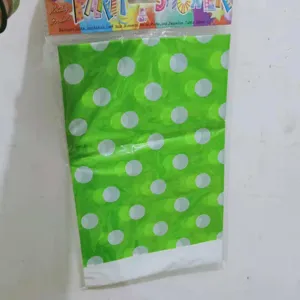 Détail d'un sac cadeau de fête en plastique vert à pois blancs dans son emballage d'origine