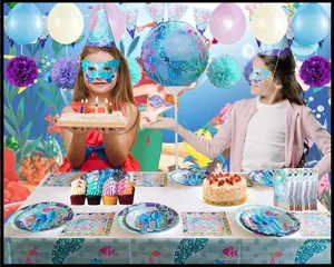 Deux filles fêtant un anniversaire sur le thème des sirènes avec une table décorée.