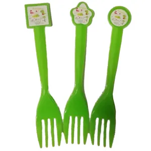 Vue détaillée de trois fourchettes en plastique vert avec décorations dinosaures