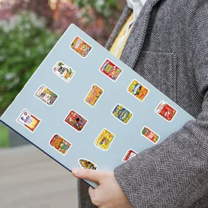 Detail view of creative parody snack packaging stickers decorated on a blue laptop surface.