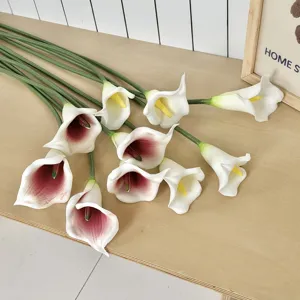 Gros plan de faux lys calla artificiels sur table en bois