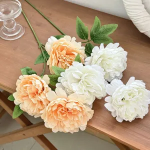 Detailed view of elegant champagne and white artificial peony silk flowers on wooden surface