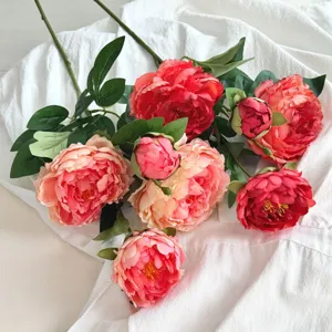 Primo piano dettagliato di fiori di peonia artificiali con petali corallo e rossi realistici