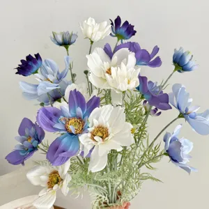 Close-up of realistic artificial cosmos flowers in blue, white, and purple for decor.