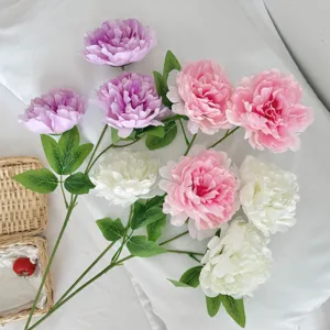 Detailed view of realistic pink and white artificial peony flowers with green leaves.