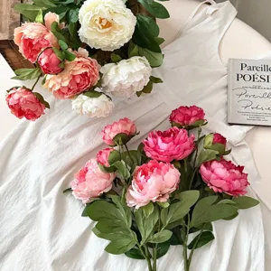 Vista dettagliata di peonie artificiali realistiche su tessuto bianco per decorazione casa