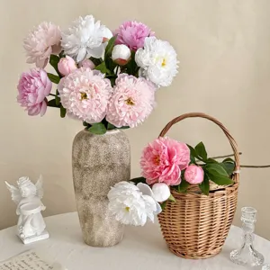 Detailed shot of artificial pink and white peonies in a ceramic vase and basket