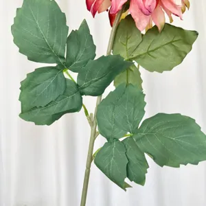Detailed close-up of realistic green leaves and stem of artificial dahlia flower