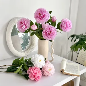 Detailed view of realistic pink and white artificial peonies placed in a cream vase
