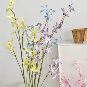 Close-up of colorful artificial dancing lady orchid stems in a minimalist setting