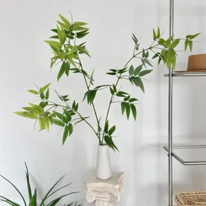 Elegant artificial bamboo leaf branch in a white ceramic vase for Zen interior home decor